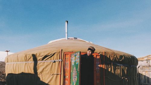 View of man in doorway of yurt