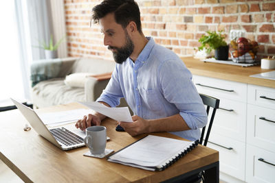 Side view of man working at table