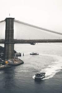 Brooklyn bridge over east river against sky