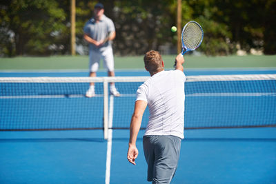 Midsection of man playing tennis