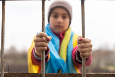 Cropped hand of woman holding metal gate