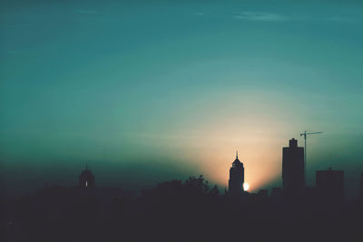 Silhouette of buildings against sky at dusk