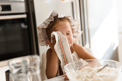 Little girl cooking pizza in the kitchen