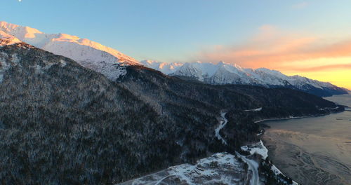 Scenic view of snowcapped mountains against sky during sunset