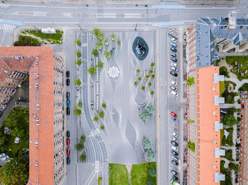 High angle view of cars on road by buildings in city