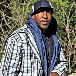 Portrait of young man standing against plants