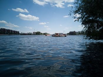 Scenic view of river by buildings against sky