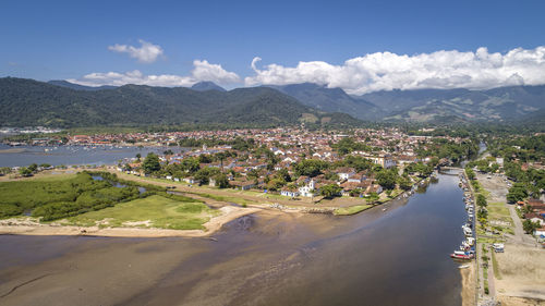 High angle view of city by sea against sky