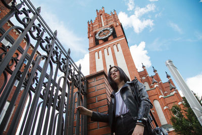 Low angle view of woman standing against buildings