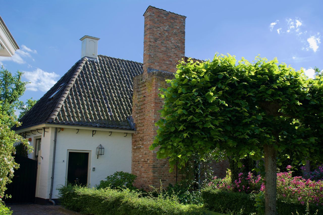 LOW ANGLE VIEW OF BUILDING AND TREES AGAINST SKY