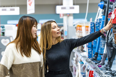 Couple of young cute multi-ethnic women are shopping in the household appliance department