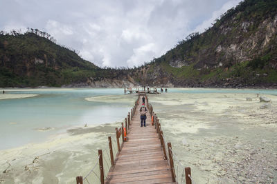 Pier over kawah putih lake against sky