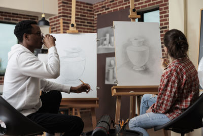 Side view of woman using mobile phone while sitting at home