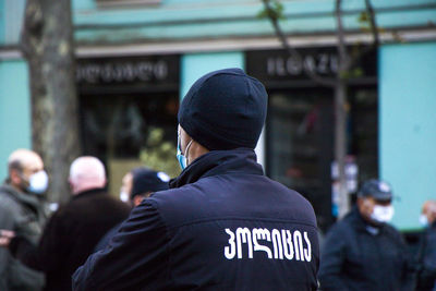 Rear view of man with text on wall in city