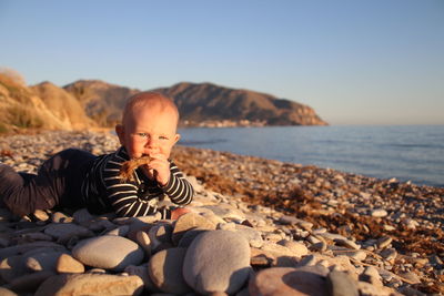 Crawling boy on stoney beach