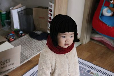 Close-up of cute thoughtful girl sitting at home