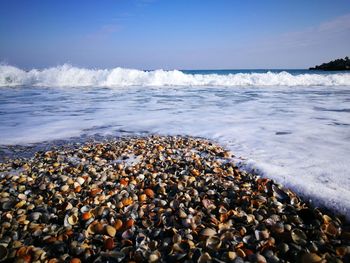 Pebbles on beach against sky