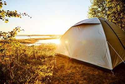 Tent on beach against clear sky at lake vänern in sweden during sunrise 