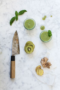 High angle view of ingredients with drink and knife on kitchen counter