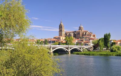 Arch bridge over river against buildings