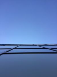 Directly below shot of modern building against clear blue sky