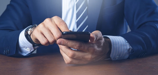 Midsection of man using mobile phone