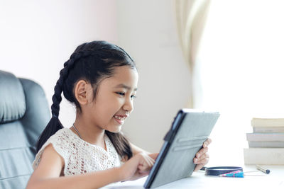 Portrait of smiling girl sitting on book