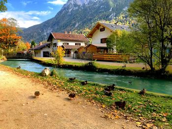 Houses by lake and buildings against sky