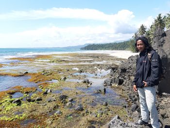 Portrait of young man standing at beach