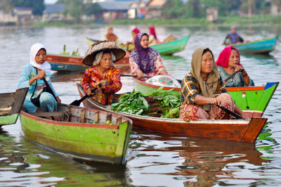 High angle view of two people sitting on riverbank