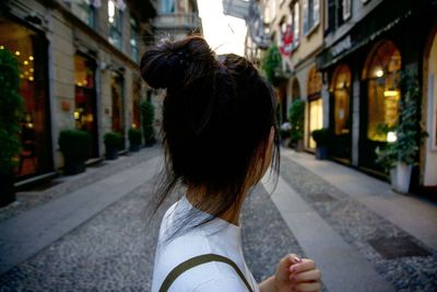 Rear view of woman walking in front of buildings