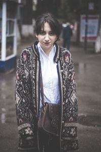 Portrait of beautiful woman standing in city