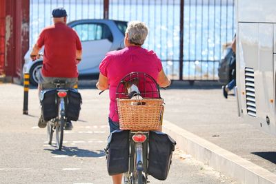 Rear view of man riding bicycle on street