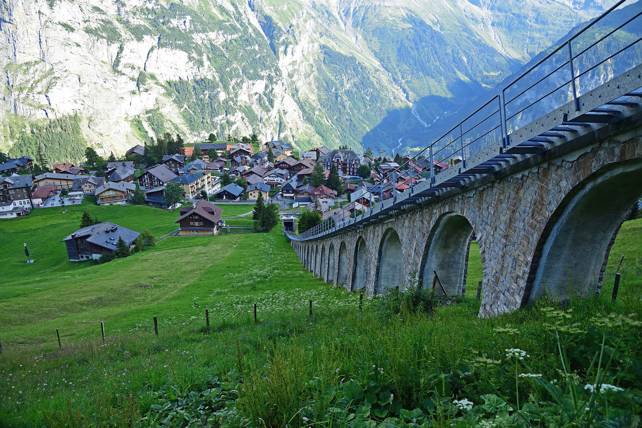 ARCH BRIDGE BY BUILDINGS AGAINST SKY