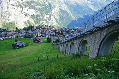 Arch bridge by buildings in city