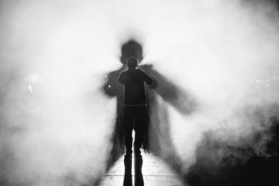 Rear view of silhouette person standing against blurred background