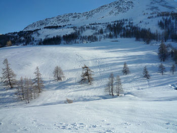 Snow covered land and mountains against sky