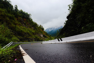 Road amidst trees against sky