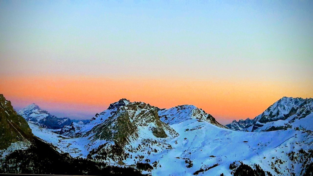 SNOW COVERED MOUNTAINS AGAINST SKY DURING SUNSET