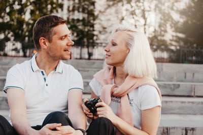 Young couple sitting outdoors