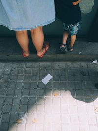 Low section of woman standing on footpath