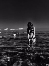 Full length of shirtless boy standing on beach against clear sky