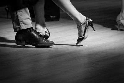 Low section of people walking on hardwood floor