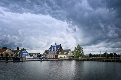 River by buildings against sky