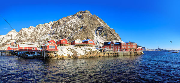 House by sea against clear blue sky