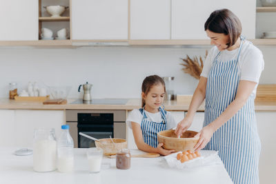 Mother and daughter preparing food at home