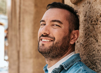 Portrait of a handsome hipster man in a jean jacket. a man in a big city on the street