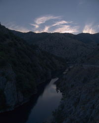 Scenic view of river amidst mountains against sky