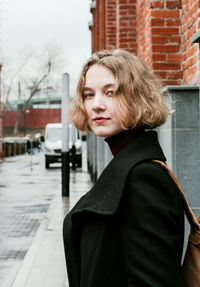 Portrait of beautiful woman standing in city