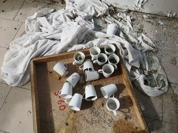 High angle view of abandoned cups on wood